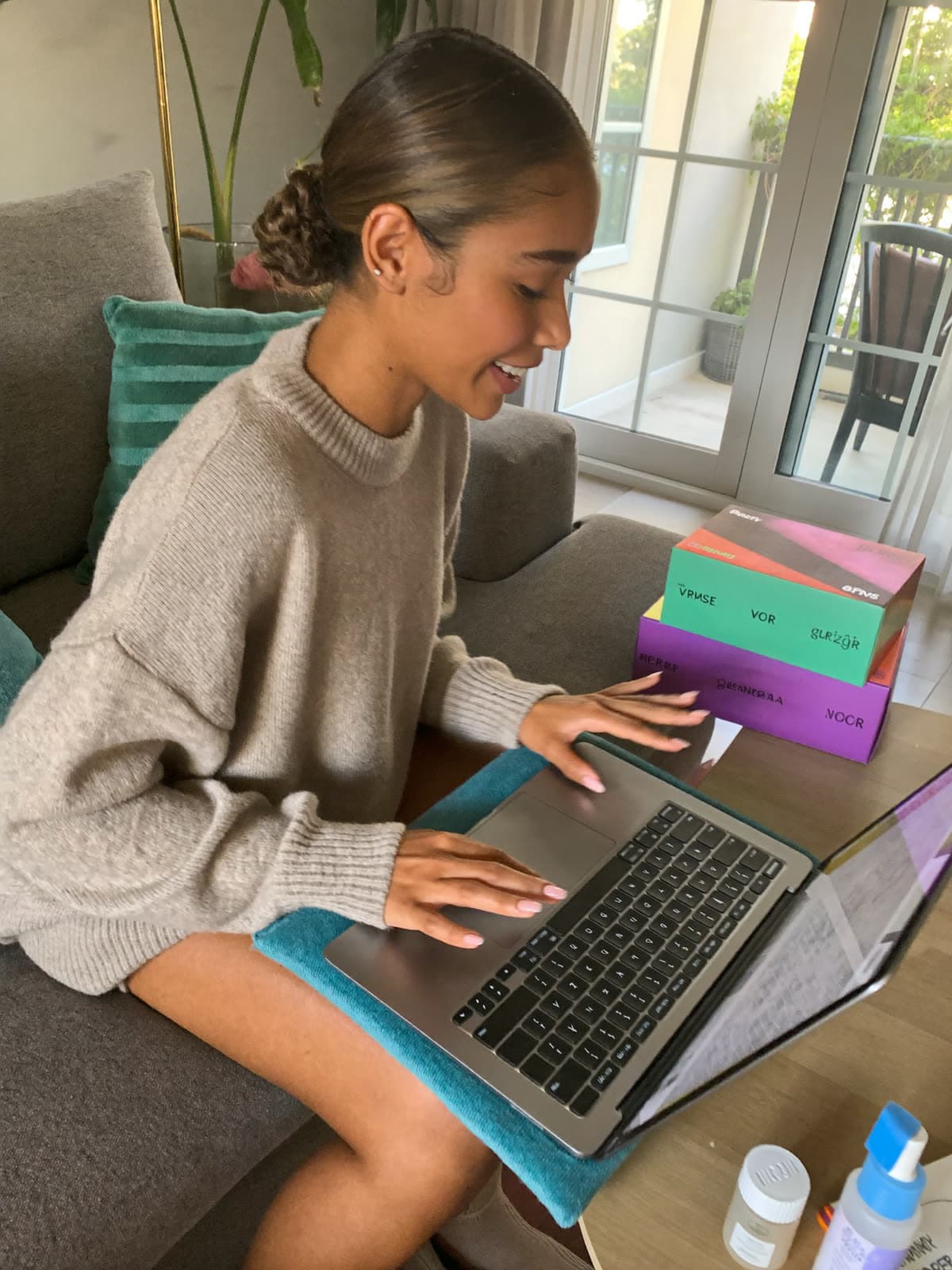 Una creadora responde correos de marcas en su laptop, con cajas de regalo en la mesa