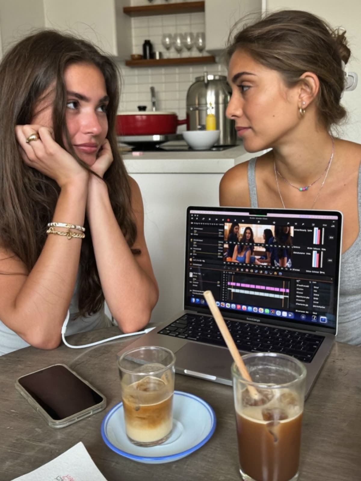 A creator and her editor review a vertical video together on a laptop
